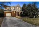 Charming two-story home features a brick facade, white trim, attached garage, and a well-manicured front lawn at 1104 Pebblestone Dr, Durham, NC 27703