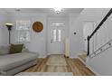 Bright entryway with stylish front door, hardwood floors, staircase, and large analog clock at 1104 Pebblestone Dr, Durham, NC 27703