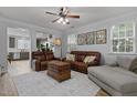 Cozy living room featuring neutral walls, wood floors, ceiling fan and comfortable leather seating at 1104 Pebblestone Dr, Durham, NC 27703