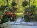 Lush backyard oasis featuring a stone pathway, vibrant flowers, and serene greenery at 11843 Canemount St, Raleigh, NC 27614