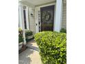 Charming front door with a floral wreath and well-maintained greenery, creating an inviting entrance at 11843 Canemount St, Raleigh, NC 27614