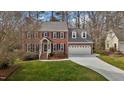 Charming brick home with a well-manicured lawn and a convenient two-car garage at 1212 Eastham Dr, Apex, NC 27502
