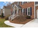 Detailed view of a brick house entrance featuring blue shutters, white trim, and a manicured lawn at 1212 Eastham Dr, Apex, NC 27502
