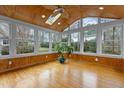 Bright sunroom boasts wood-paneled walls, hardwood floors, a ceiling fan, and abundant natural light at 1212 Eastham Dr, Apex, NC 27502