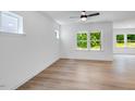 Bright and airy living room with wood floors and large windows offering serene views of the outdoors at 136 Blue Butterfly Dr, Angier, NC 27501