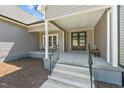 Inviting front porch features stylish seating and a covered entrance with elegant double doors at 1604 Palmer Dr, Graham, NC 27253