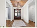 Elegant foyer featuring a wood-paneled ceiling, stylish light fixture, and attractive double front doors at 1636 Sweetwater Ln, Raleigh, NC 27610