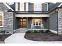 Inviting front porch with a double-door entrance, complemented by rocking chairs and meticulous landscaping at 1636 Sweetwater Ln, Raleigh, NC 27610