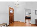 Bright foyer with hardwood floors, complemented by a chandelier and a view into the living room at 207 Linden Ave, Raleigh, NC 27601