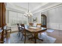 Formal dining room with a chandelier, large windows, and classic wainscoting at 242 Sweet Pine Cir, Pittsboro, NC 27312