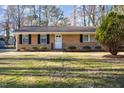 Inviting ranch-style home with brick exterior, lush landscaping and a manicured lawn at 2606 Landis Dr, Durham, NC 27705