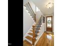 Elegant entryway featuring hardwood floors, a staircase with wrought iron railings, and a stained-glass front door at 2609 Packhouse Rd, Zebulon, NC 27597
