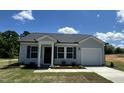 Charming single-Gathering home featuring gray siding, a black roof, a well-manicured lawn, and an attached garage at 272 Johnson Ridge Way, Four Oaks, NC 27524