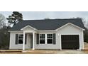 Inviting single-story home with light siding, dark shutters, covered entryway and attached garage at 272 Johnson Ridge Way, Four Oaks, NC 27524