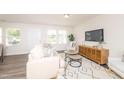 Bright living room with modern furniture, wood floors, and large windows for natural light at 272 Johnson Ridge Way, Four Oaks, NC 27524