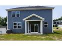 Backyard featuring a covered patio with sliding glass door and blue siding at 28 Longdale Dr, Graham, NC 27253