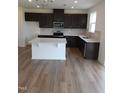 Open kitchen featuring dark brown cabinets, stainless steel appliances, white countertops and an island at 28 Longdale Dr, Graham, NC 27253