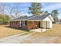 Cozy brick home with a covered carport, providing ample parking and protection from the elements at 307 S Main St, Four Oaks, NC 27524