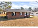 Well-maintained brick house with a dark roof and manicured lawn offering great curb appeal at 307 S Main St, Four Oaks, NC 27524