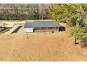 Rear view of a brick home featuring a spacious yard and mature trees, ideal for outdoor activities at 307 S Main St, Four Oaks, NC 27524