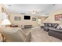 Large living room featuring a ceiling fan, plush carpeting, and abundant seating arrangements at 310 Mineral Spring Ln, Fuquay Varina, NC 27526