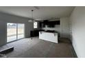 Spacious kitchen featuring sleek black cabinetry, a peninsula with breakfast bar, and sliding glass doors at 51 Robert Howe Dr, Fuquay Varina, NC 27526