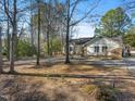Serene view of a single-Gathering home nestled amongst mature trees, offering privacy and shade at 573 Broadmoor Ct, Sanford, NC 27332