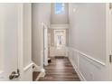 Bright hallway with a soaring ceiling, board and batten detail, and wood-look flooring at 702 Great Eno Path, Hillsborough, NC 27278