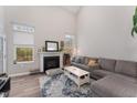 Open living room featuring a fireplace, large windows and a comfortable gray sectional sofa at 702 Great Eno Path, Hillsborough, NC 27278