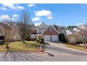 Charming two-story brick home featuring a well-manicured lawn and a two-car garage on a sunny day at 715 Southshore Pkwy, Durham, NC 27703