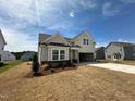 Beautiful new construction home with light siding, a covered porch, and a convenient two-car garage at 720 Hipwood Dr, Zebulon, NC 27597