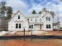 New construction home with black window frames, grey shingles, and covered in Exeter guard house wrap at 7429 Wexford Woods Ln, Wake Forest, NC 27587