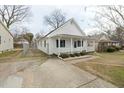 Exterior view showcasing the home's fenced yard and updated driveway that leads to the cozy front porch at 847 Estes St, Durham, NC 27701