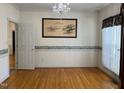 Bright dining room with hardwood floors, chandelier, decorative wallpaper border, and large window with curtain at 100 Sandy Hook Way, Cary, NC 27513
