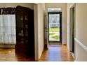Inviting entryway with wood floors, decorative cabinet, and view of a well-manicured front yard through the glass front door at 100 Sandy Hook Way, Cary, NC 27513