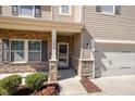 Inviting front entrance with stone accents, manicured bushes and a covered front porch at 1008 Scotch Pine Way, Mebane, NC 27302