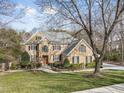 Spacious brick home with a well-maintained lawn, complemented by mature trees offering shade and privacy at 102 Shepton Dr, Cary, NC 27519