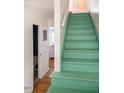 Bright, light green painted staircase with white trim and wood flooring in a modern home at 105 Fidelity St # B24, Carrboro, NC 27510