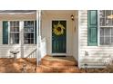 Close up view of the front door, showing the yellow wreath, green door and brick steps at 1109 Sorcerer Ct Ct, Knightdale, NC 27545