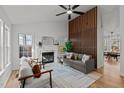 Bright living room showcasing a fireplace, light grey sofa and chairs, with wood accent wall at 1109 Sorcerer Ct Ct, Knightdale, NC 27545