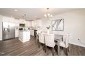 Well-lit dining area connected to the kitchen, featuring modern lighting and stainless steel appliances at 114 Johnson Ridge Way, Four Oaks, NC 27524