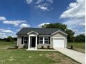 Charming single-story home with vinyl siding, black shutters, and a well-manicured front yard at 114 Johnson Ridge Way, Four Oaks, NC 27524