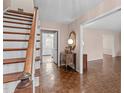 Inviting foyer features hardwood floors, staircase, and entryway offering a glimpse of the kitchen at 115 Perth Pl, Durham, NC 27712