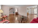 Spacious living room with hardwood floors and neutral walls, leading into other rooms in the home at 115 Perth Pl, Durham, NC 27712