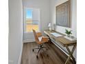 Bright home office with wood desk, comfortable chair, modern art, and large window with view of the yard at 120 Whistling Way # Cary Traditiol, Lillington, NC 27546