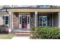 Inviting front porch with brick accents, decorative lighting, and a charming front door at 17 Beckwith Ave, Clayton, NC 27527