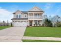 Beautiful two-story house featuring a well-manicured lawn and a two-car garage with a long driveway at 1783 Ballard Rd # Apex Georgian, Fuquay Varina, NC 27526