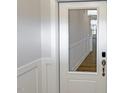 Bright entryway showcasing white wainscoting and a glass panel door with wood-look floors at 1803 Ballard Rd # Holly Craftsman, Fuquay Varina, NC 27526