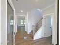 Welcoming foyer with wood-look tile flooring, staircase, and views into other rooms at 1803 Ballard Rd # Holly Craftsman, Fuquay Varina, NC 27526