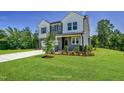 Charming two-story home featuring a welcoming entrance, a two car garage and landscaped front yard at 1803 Ballard Rd # Holly Craftsman, Fuquay Varina, NC 27526